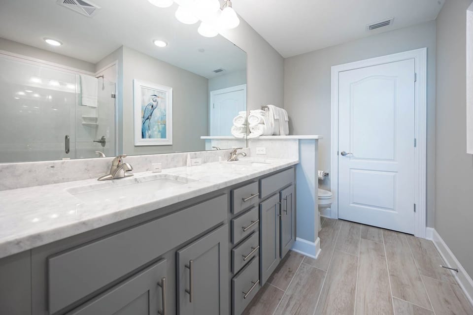 Refresh in the master bath after a day at the beach with a relaxing walk-in glass shower