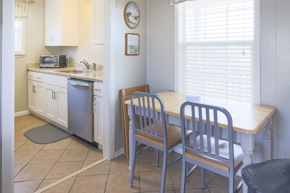 This kitchen features sleek stainless appliances, granite countertops, and a cozy dining area with natural light