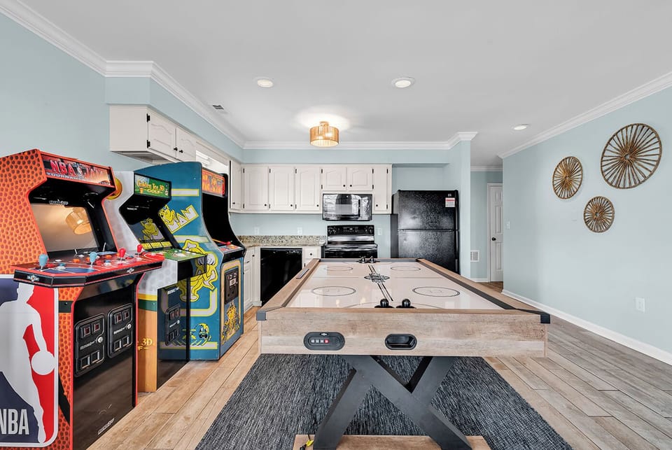 The game room with air hockey, foosball, arcade games, seating, and Roku TV 