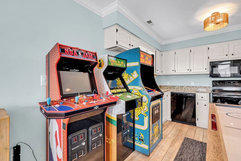 The game room with air hockey, foosball, arcade games, seating, and Roku TV 