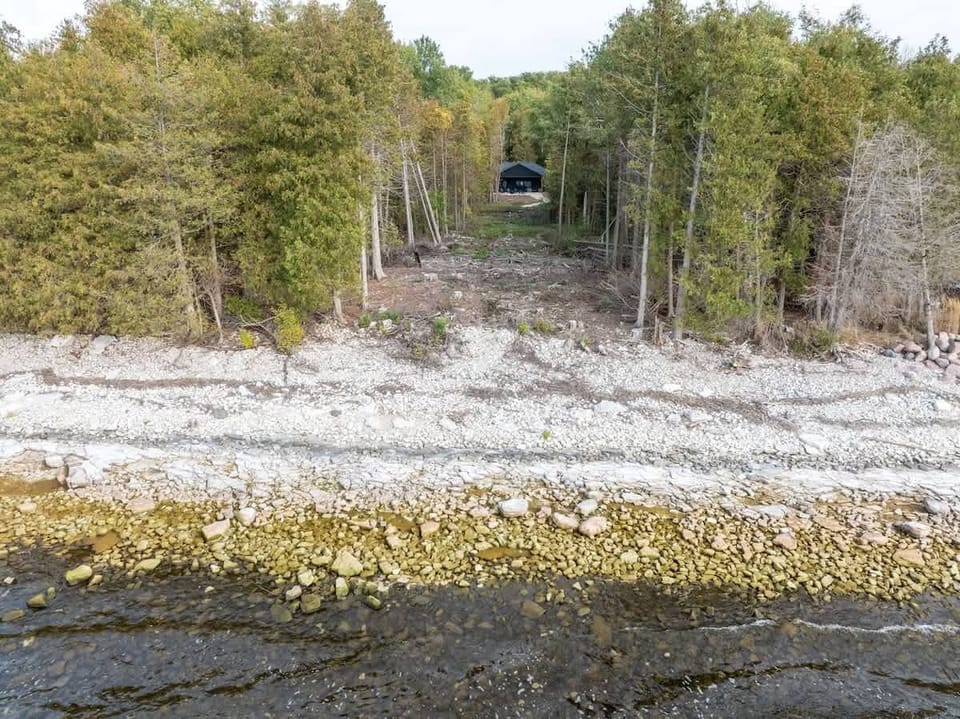 One hundred feet of Green Bay shoreline, accessible for most of the year to those comfortable navigating the natural, uneven terrain. The owner is planning future improvements to enhance accessibility.