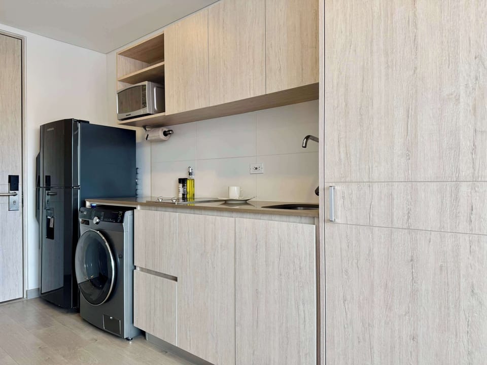 Kitchen area with integrated washer and minimalist cabinets.