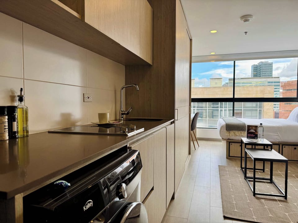 Sleek kitchen with a dining table and large windows.