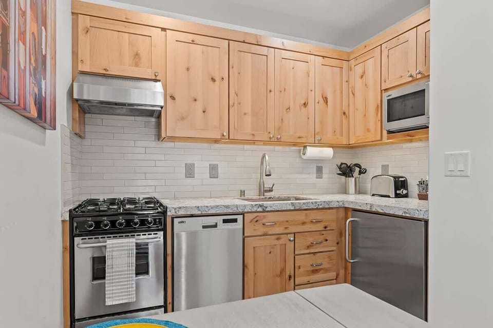Upgraded Kitchen with beautiful cabinetry, gas 4-burner range and oven, under the counter fridge, dishwasher and sink with Gooseneck faucet