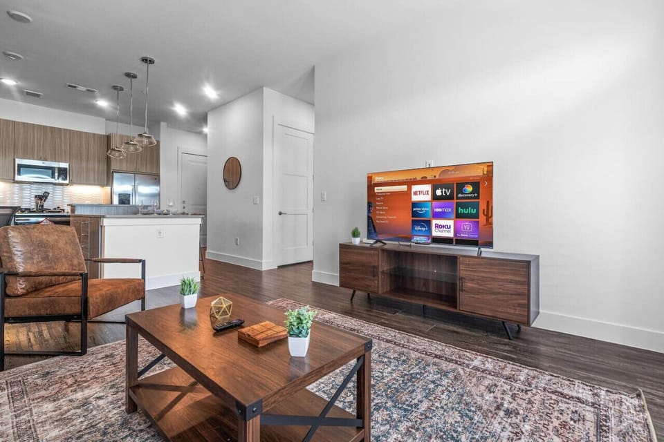 Bright and airy living room with plush seating, a large TV, and tasteful decor, creating the perfect space for relaxation and entertainment.