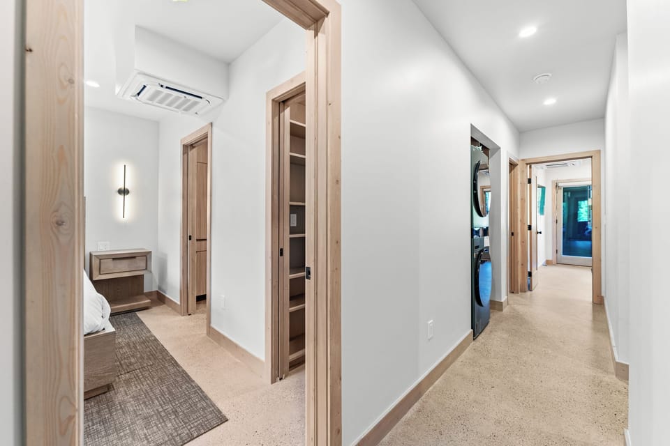 Bright hallway with warm wood trim connects your spaces, featuring convenient laundry and storage access.