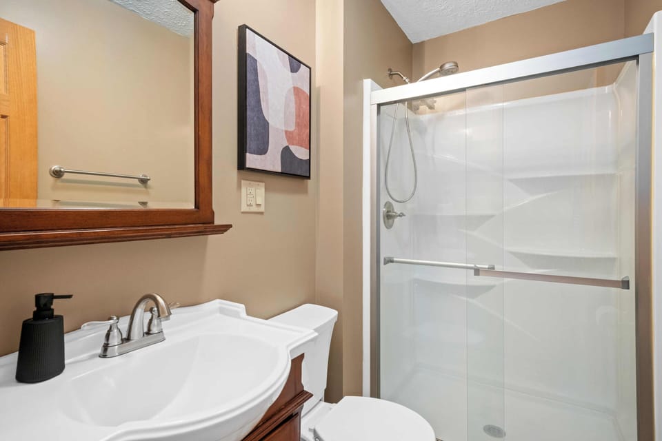 Walk in shower in the master bathroom with sleek glass doors.  