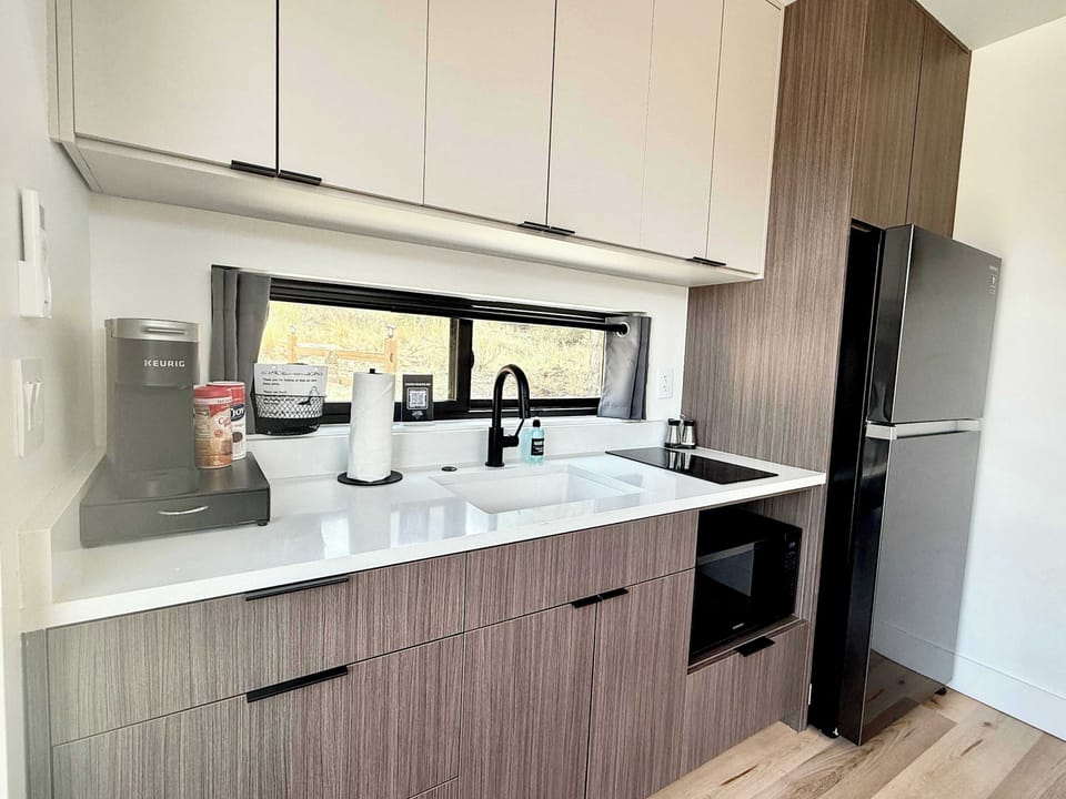 Luxury kitchenette with a large refrigerator, cooking utensils, and essentials for preparing simple meals during your Southern Utah cabin stay.