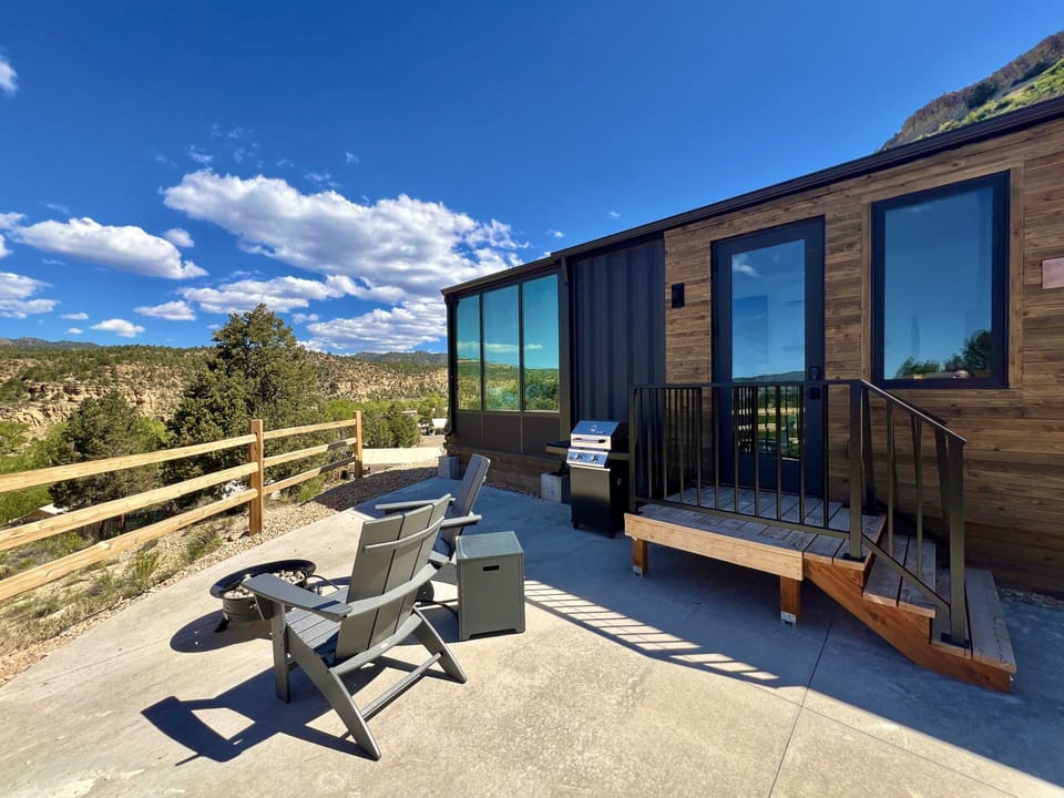 Private outdoor seating area nestled in the trees with a BBQ grill, gas fire pit, and stargazing at night during your peaceful Southern Utah cabin stay.