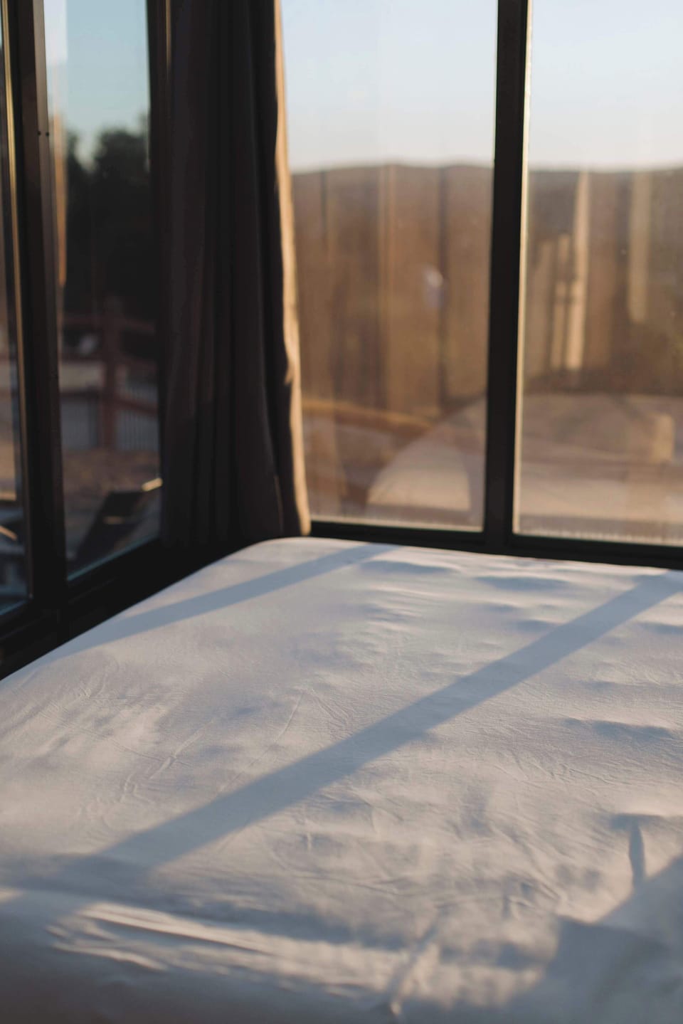 Cozy queen bed with scenic window views, creating a peaceful place to recharge after exploring Southern Utah.