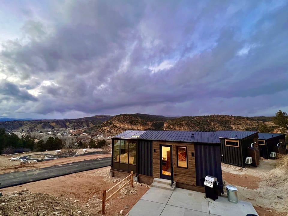 Exterior view of Wild Sage, a modern container cabin at East Zion Resort with large windows, mountain views, and peaceful Southern Utah scenery.
