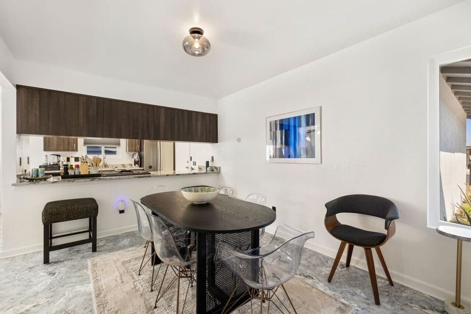 Intimate dining nook w/ modern chairs and natural light—ideal for morning coffee or casual meals.