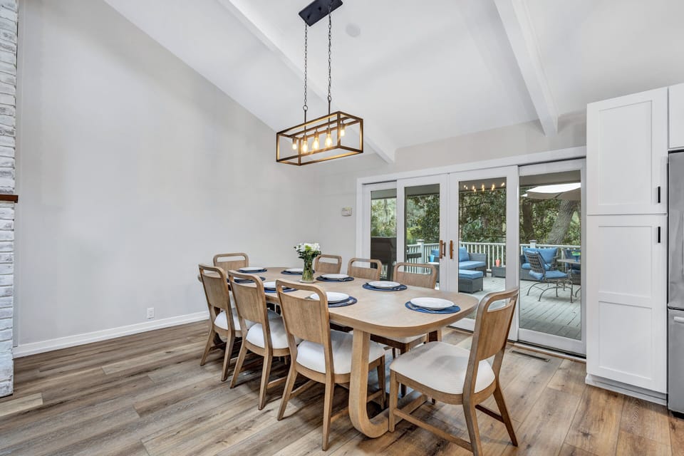 Open-plan layout of the main level living area transforms mealtime into a joyous occasion, offering ample seating at the kitchen island and adjacent dining tables.