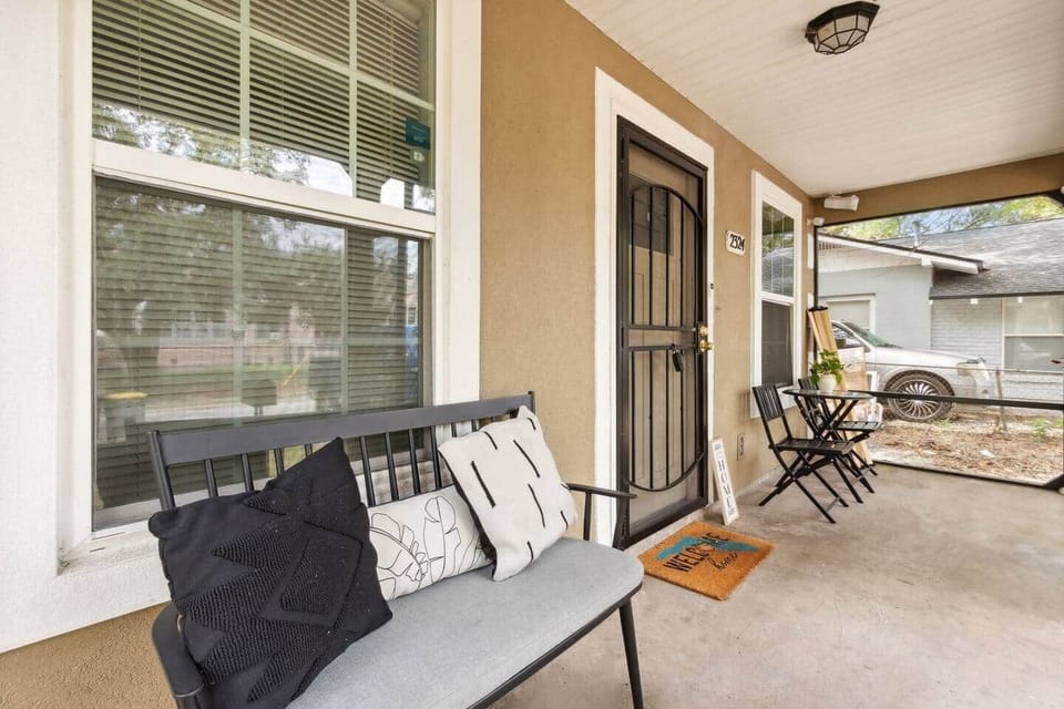 Step through the front door and onto the inviting screened-in porch, furnished with a table, two chairs, and a cozy side bench. This is the perfect spot to unwind with a book, enjoy a meal, or simply watch the world go by.