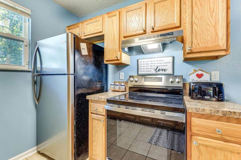 Stainless steel appliances: A refrigerator, stove, microwave, toaster. 