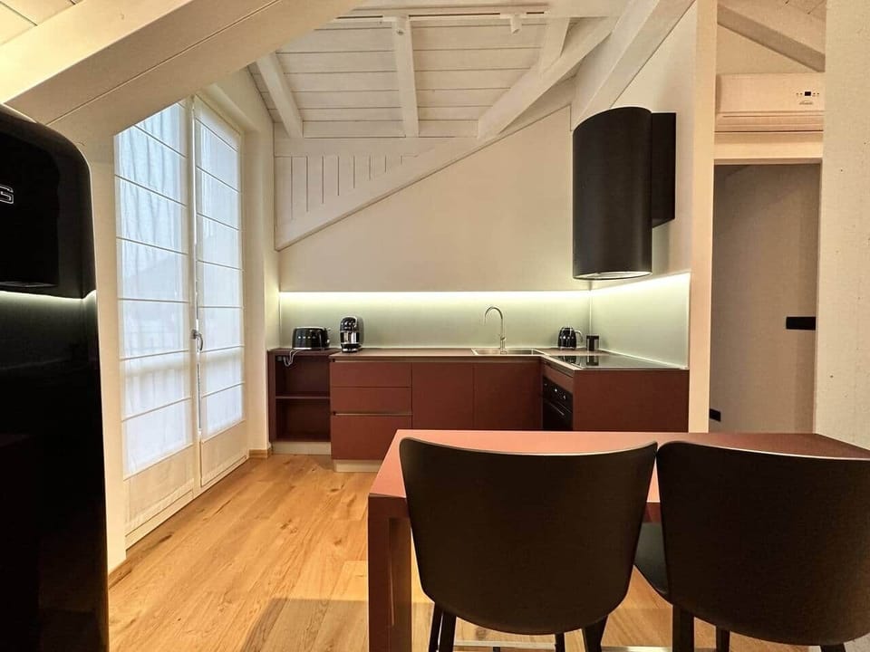 Kitchenette equipped with SMEG accessories, induction cooktop, combined electric and microwave oven, dishwasher, refrigerator, Lavazza pod coffee maker, kettle, toaster, dishes, plates, glasses and cutlery. 