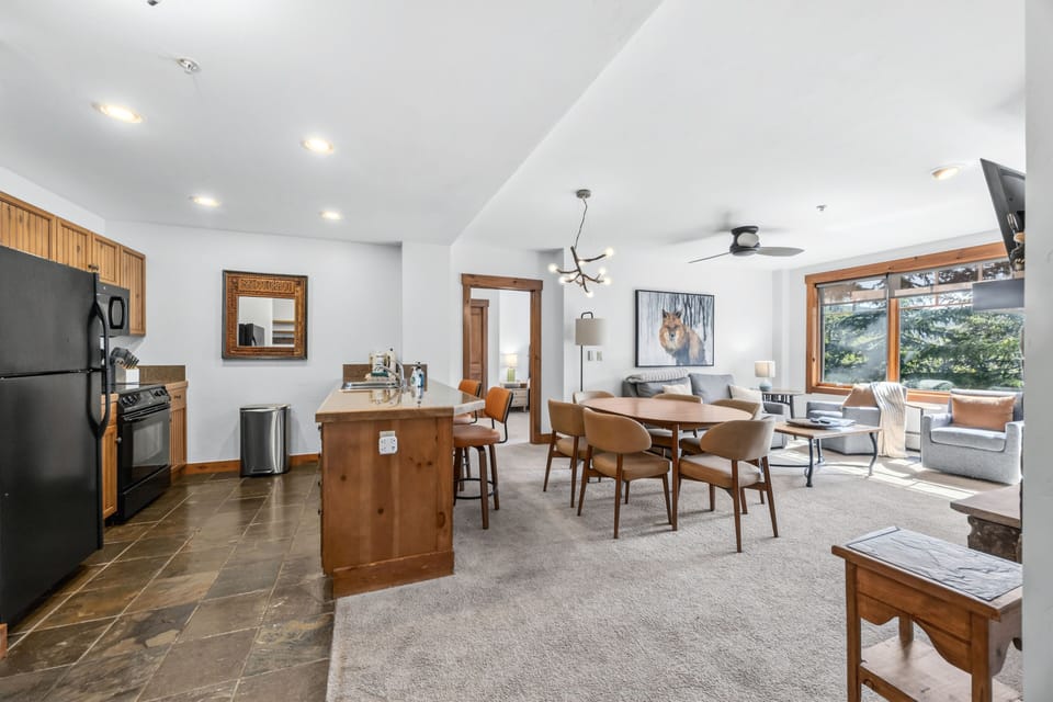 Open plan from the kitchen end — pine view through it all.