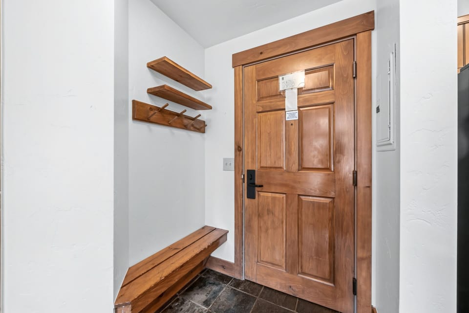Foyer entry — slate floor and coat-hook shelf.