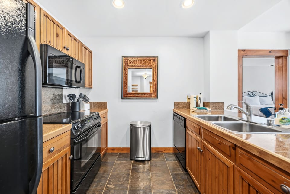 Kitchen galley — knotty pine cabinets and slate floor.