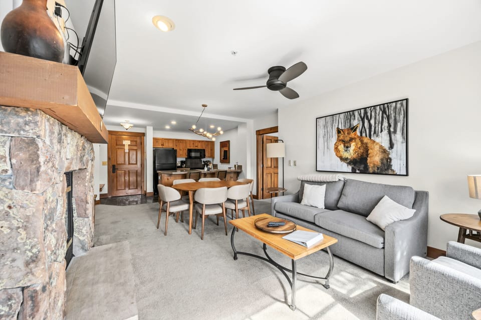 Living with stone fireplace and dining adjacent.