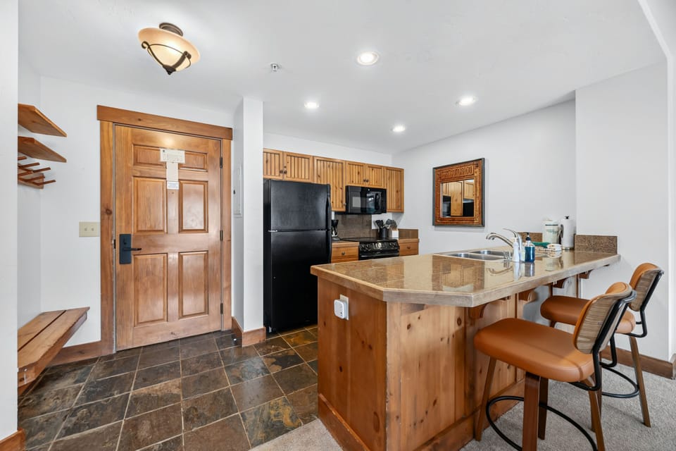 Kitchen breakfast bar with orange-leather counter stools.
