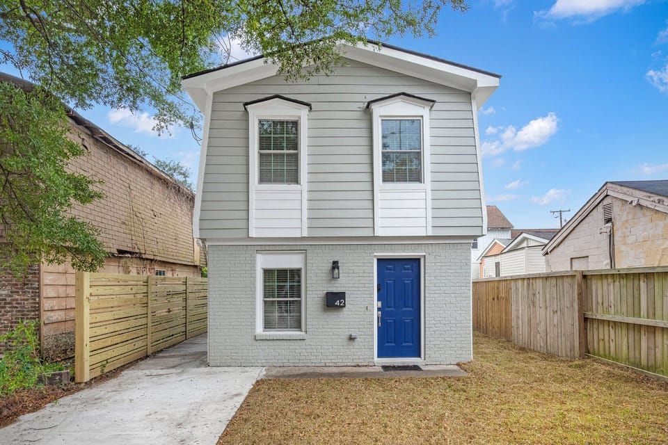 Cozy two-story home with modern grey exterior and private fenced yard.