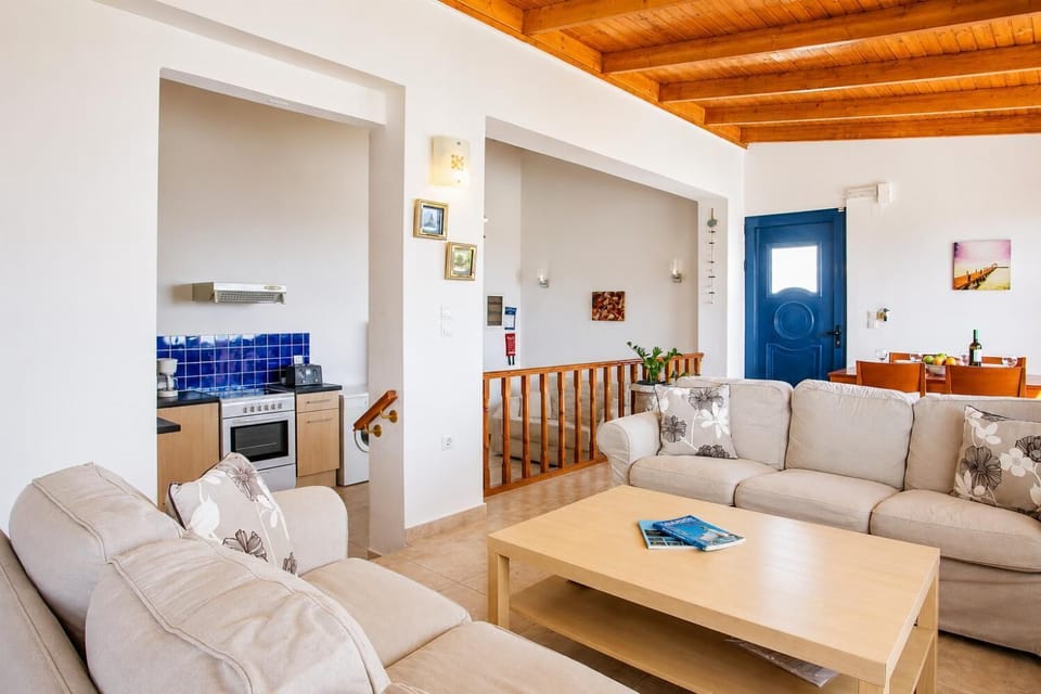 Open-plan living room with sofa, dining area, kitchen, A/C, WiFi internet, and satellite TV