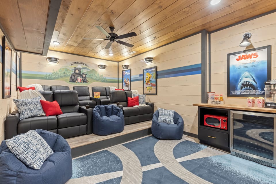 Enjoy movie nights in a home theater featuring cozy seating, a 75” smart TV