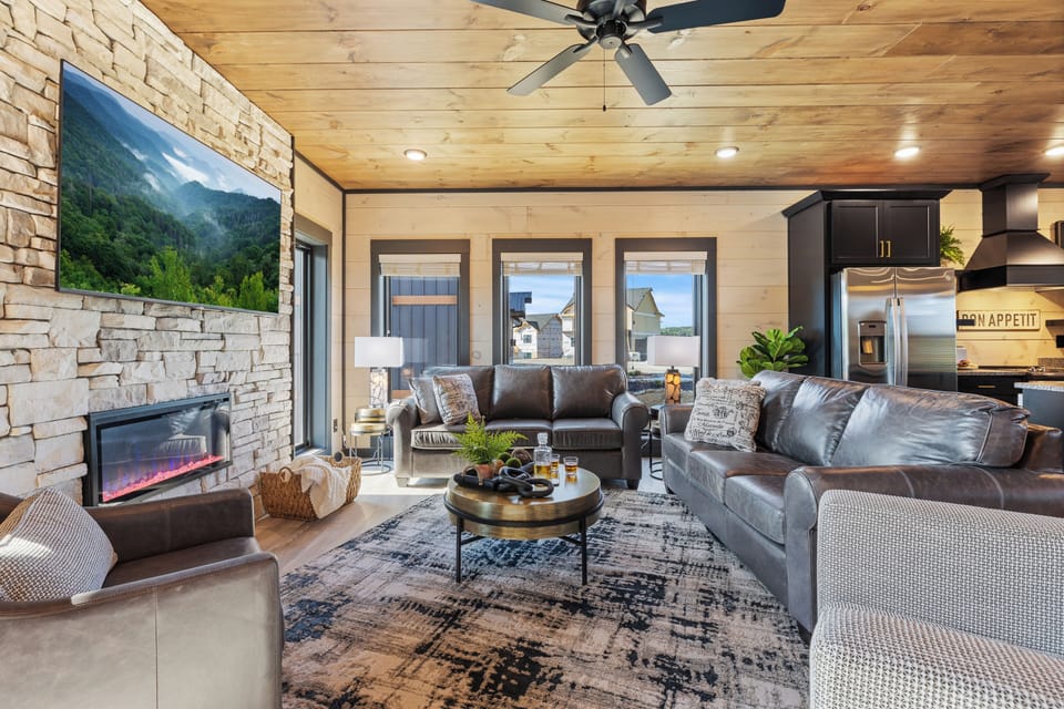 Gather in the spacious main-floor living room with a 65” smart TV, electric fireplace, and cozy seating—perfect for family moments or quiet nights in.