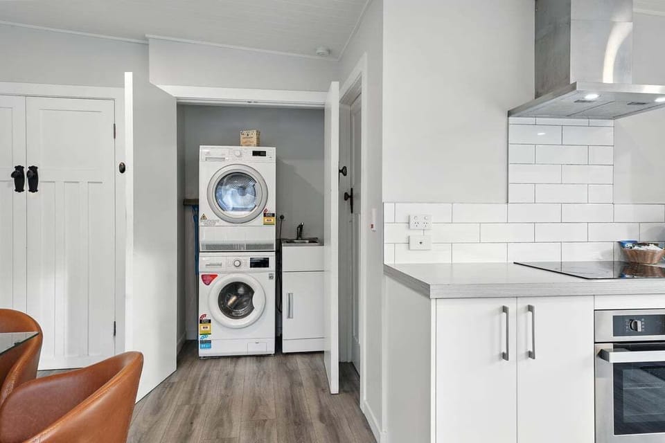 Convenient laundry nook with a washing machine and separate dryer — perfect for longer stays.