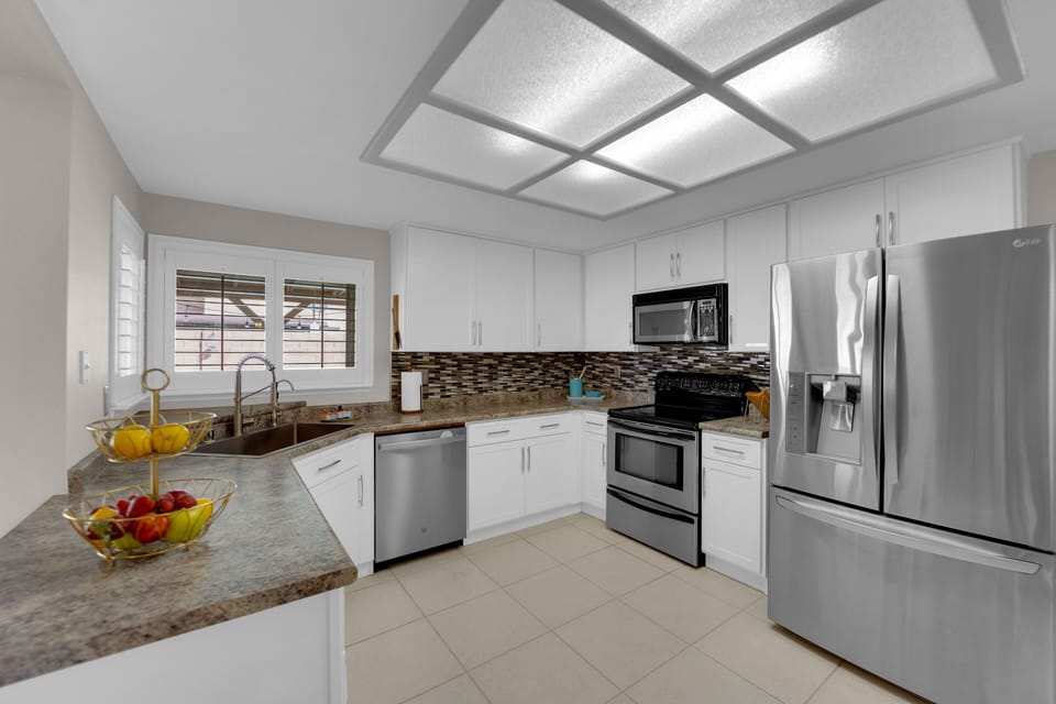 The main level features a highly upgraded eat-in kitchen with crisp white cabinets, a sleek stainless steel appliance package, and ample counter space, making it a chef's delight.