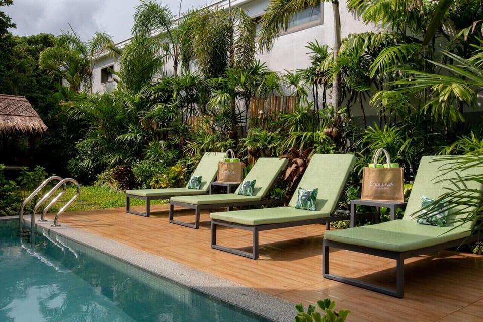 Tropical poolside with lounge chairs and lush garden at C Villa 8-bedroom Koh Samui retreat
