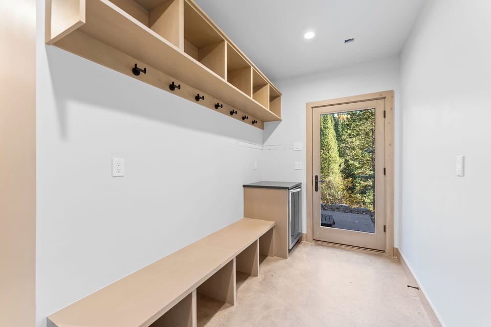 Your own mudroom keeps belongings organized with custom wood storage cubbies and a convenient bench for easy transitions.