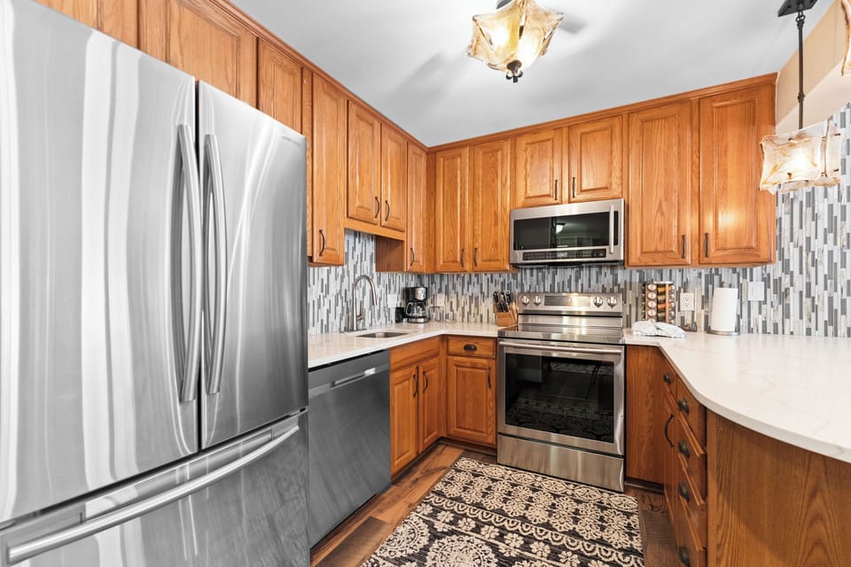 Full kitchen with stainless steel appliances, and breakfast bar with seating for 4.