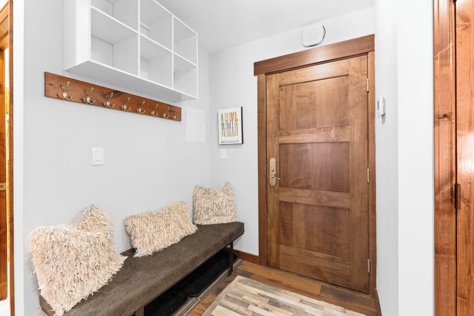 Interior unit entryway with bench and storage space.
