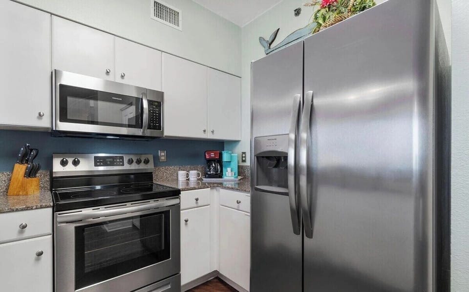 Full kitchen with stainless steel appliances and equipped with basic cooking essentials.