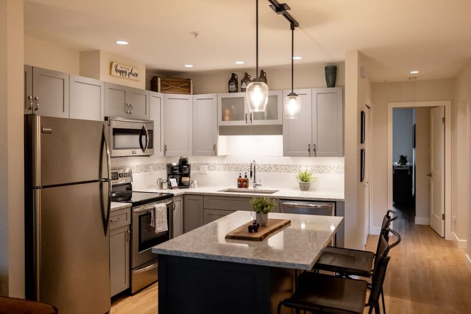 The spacious island serves as a multifunctional hub for meal prep, casual dining, or gathering with friends and family.