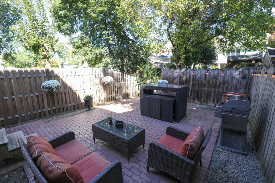 Fenced inn back patio seating area with outdoor dining table and chairs
