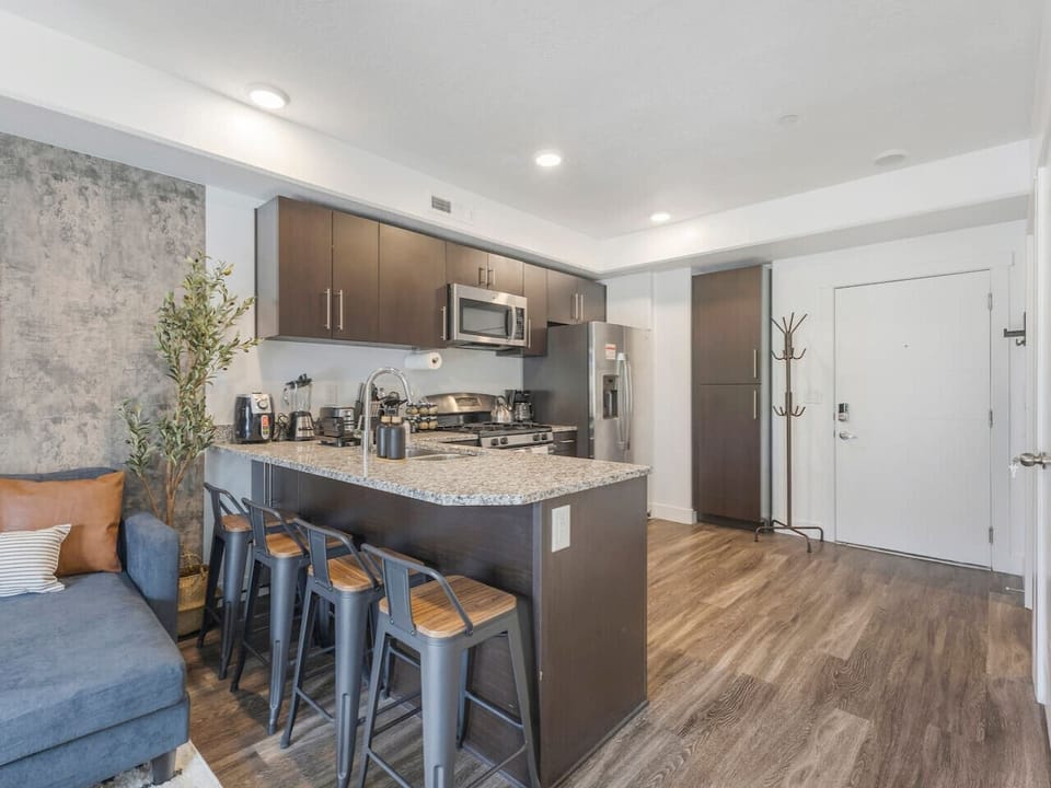 Modern kitchen with granite island, bar seating, and stainless steel appliances — perfect for cooking and gathering 🍴✨🥂