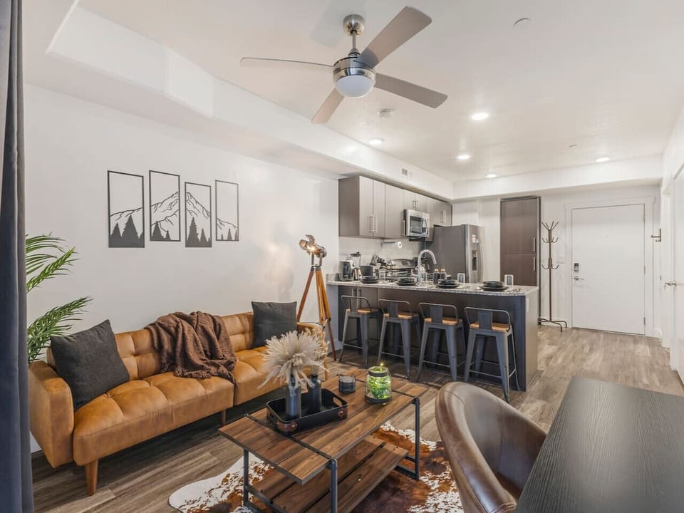 Open-concept living space with modern kitchen, cozy sofa, and warm décor perfect for relaxing or entertaining ✨🛋️