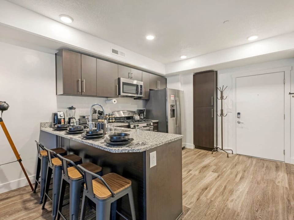 Modern kitchen with stainless steel appliances, granite countertops, and a breakfast bar ready for shared meals 🍴✨