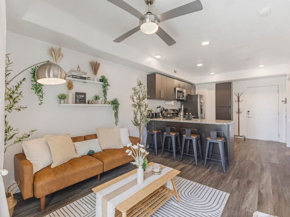 Open-concept living with a cozy sofa, stylish décor, and a modern kitchen 🛋️🍷✨—perfect for relaxing or entertaining!