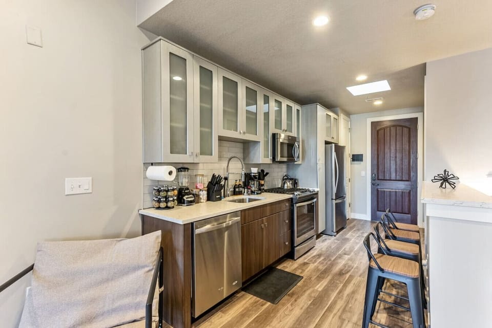 Kitchenette w/ bar seating, compact appliances & essentials for quick meals