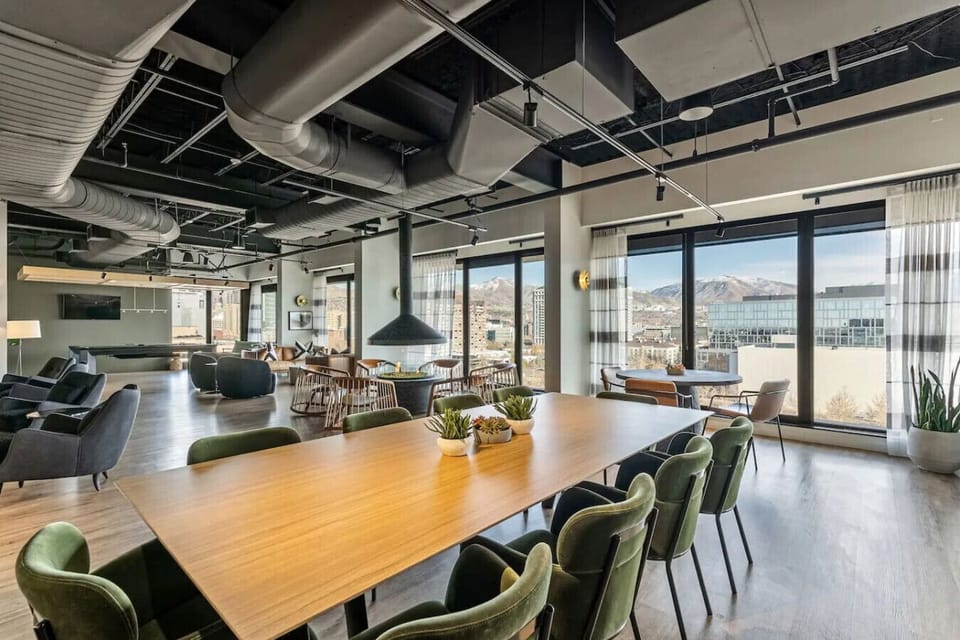 Open lounge area w/ long table, stylish seating & relaxed social atmosphere