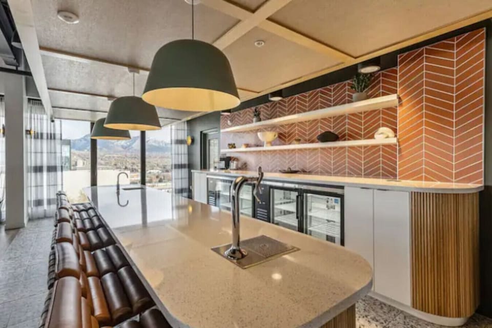 Modern shared kitchen w/ bar seating, pendant lighting & sleek finishes