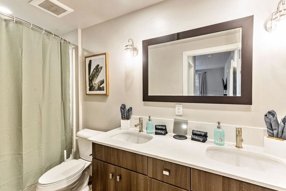 Clean bathroom w/ vanity, large mirror & shower w/ curtain