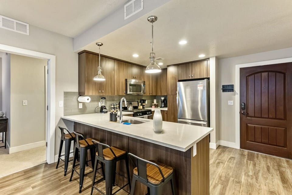 Modern kitchen w/ large island seating, pendant lighting & stainless appliances
