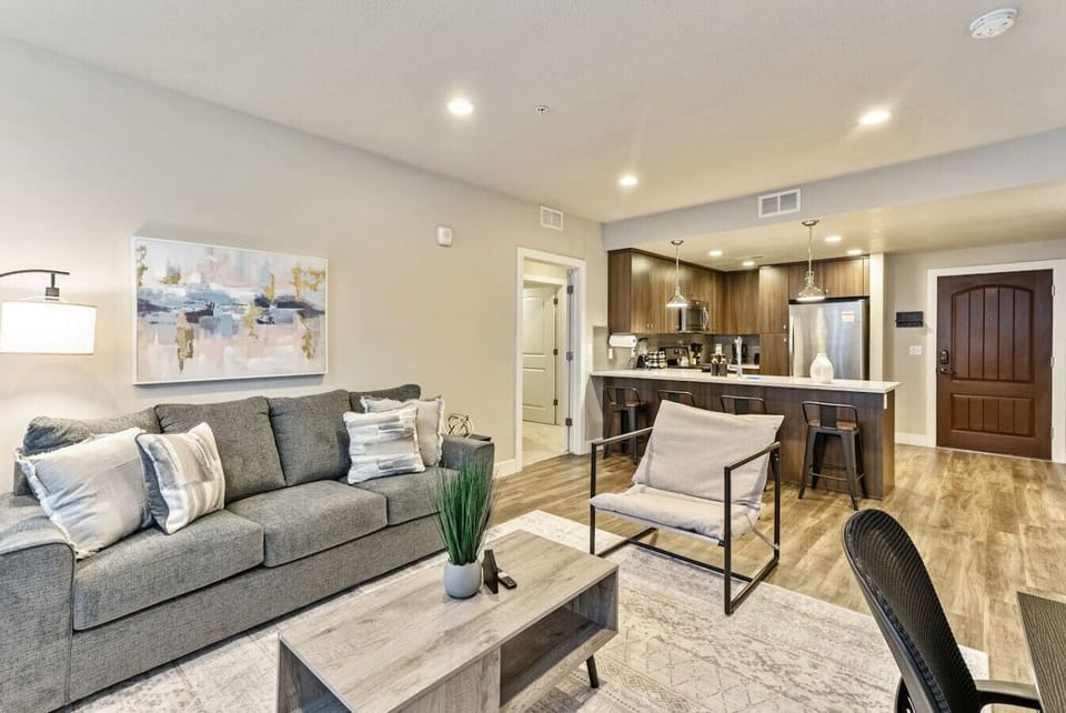 Open living space w/ comfy sofa, wall art & seamless flow into the kitchen