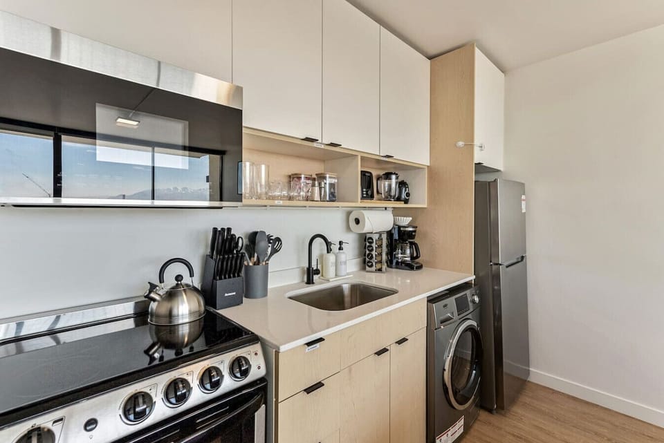 Fully equipped kitchen with stove, fridge, microwave, and washer-dryer for convenience 🍳🧺