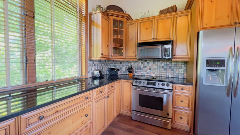 Fully equipped kitchen with stainless appliances and extra seating. 